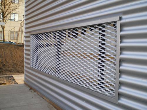 Architectural expanded metal with diamond holes and larger openings as window of metal wall.