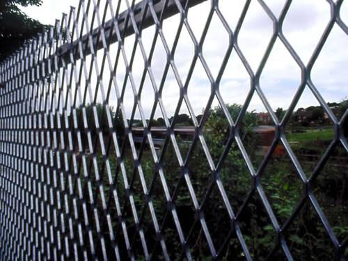Expanded metal fencing with black surface, diamond holes and sharp top side.