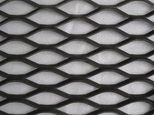 Expanded metal steel sheet details with black surface and hexagonal holes.