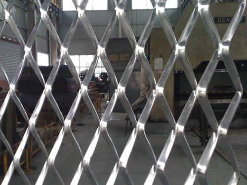 Raised expanded metal fencing made of aluminum with diamond holes in the factory.