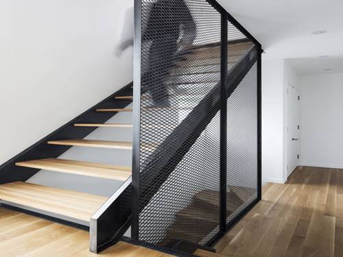 Expanded metal stair railing with black surface and diamond holes at homes.